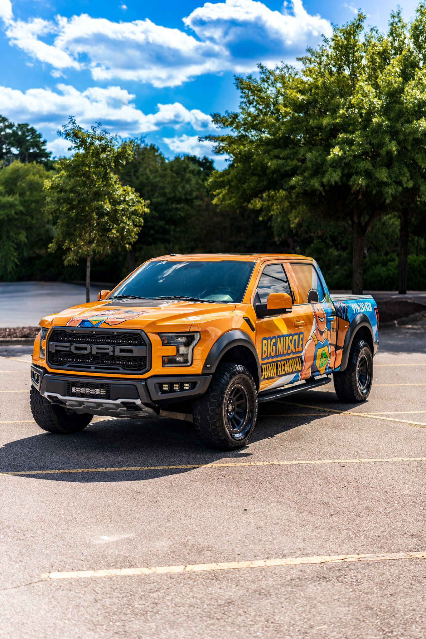 Big Muscle Junk Removal wrapped pickup truck — front three-quarter view