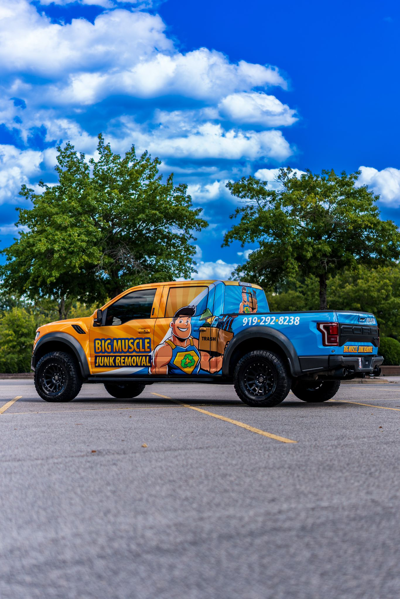 Big Muscle Junk Removal wrapped pickup truck — side profile view